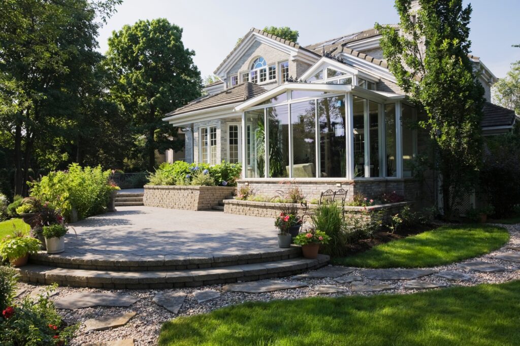 Brick and stone cottage style home with sunroom, patio and landscaped backyard, Quebec, Canada